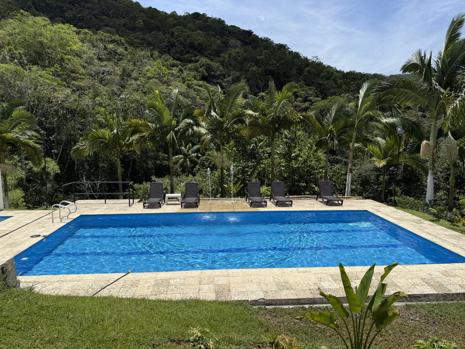 Piscinas del hotel rodeadas de jardines y montañas